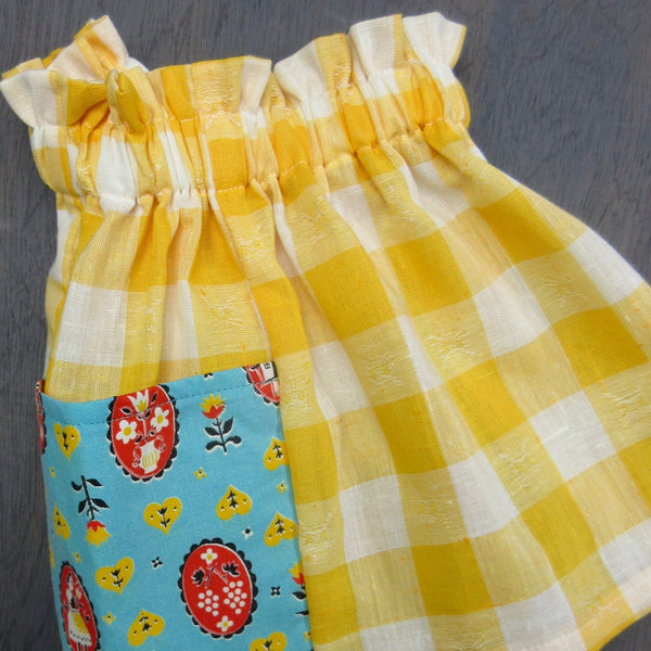 Child's vintage yellow gingham linen and cotton skirt with turquoise, red, yellow and black patterned pockets, size 3